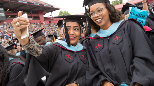 Happy Graduate School of Education grads take a selfie during commencement